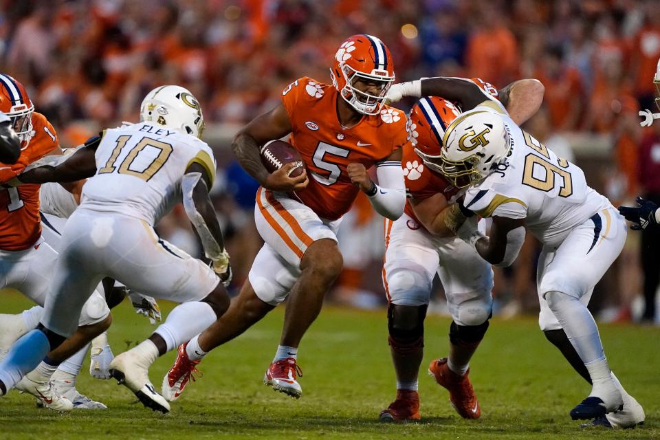 Clemson quarterback D.J. Uiagalelei (5) runs through the line as Georgia Tech's Ayinde Eley (10) and D'Quan Douse (99) close in during the second half Saturday, Sept. 18, 2021, in Clemson, S.C.