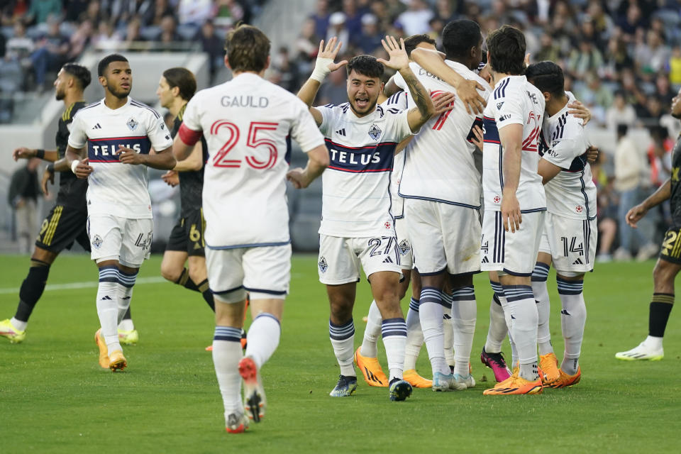 Vancouver Whitecaps players celebrate after defender Ranko Veselinovic (4) scored during the first half of an MLS soccer match against Los Angeles FC in Los Angeles, Saturday, June 24, 2023. (AP Photo/Ashley Landis)