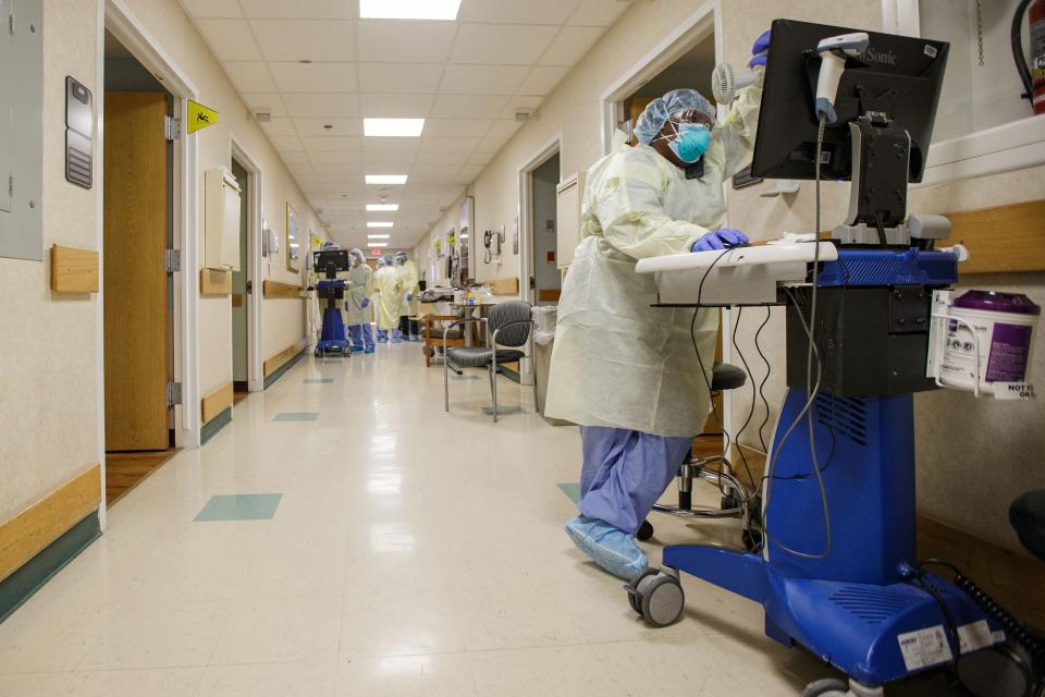 Regina Bolde, 50, who has been a nurse at Tallahassee Memorial HealthCare since 2015, holds a portable fan towards her face to help cool down while dressed in PPE and working in the yellow level COVID unit Monday, Aug. 23, 2021.