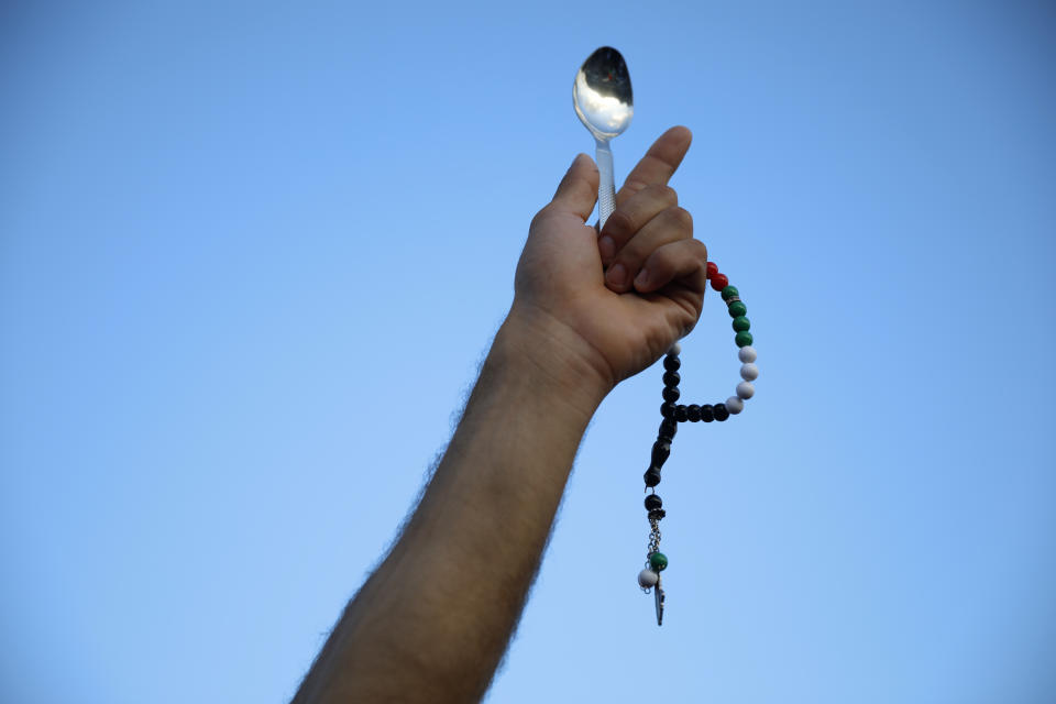 A protester holds a spoon, which has become a symbol celebrating the six Palestinian prisoners who recently tunneled out of Gilboa Prison, in Umm el-Fahm, Israel, Friday, Sept. 10, 2021. (AP Photo/Ariel Schalit)