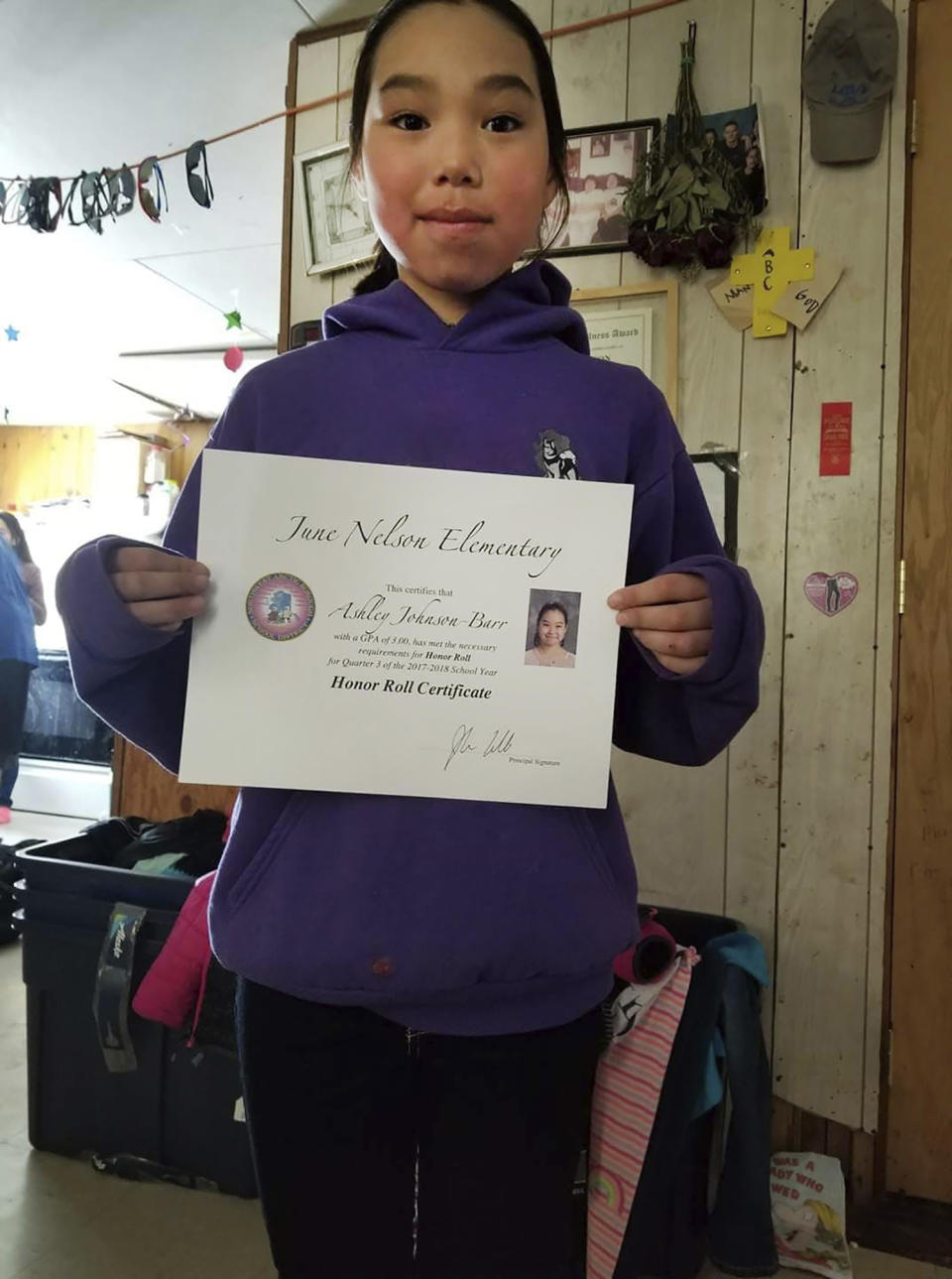 This 2018 photo provided by Scotty Barr shows his daughter Ashley Johnson Barr holding her Honor Roll certificate. Ashley was killed in Kotzebue, Alaska, in September 2018. Peter Wilson, of Kotzebue, Alaska, has pleaded guilty to first-degree murder and sexual abuse of a minor in Ashley's death, and will be sentenced Sept. 21, 2021, in Kotzebue. (Courtesy of Scotty Barr via AP)