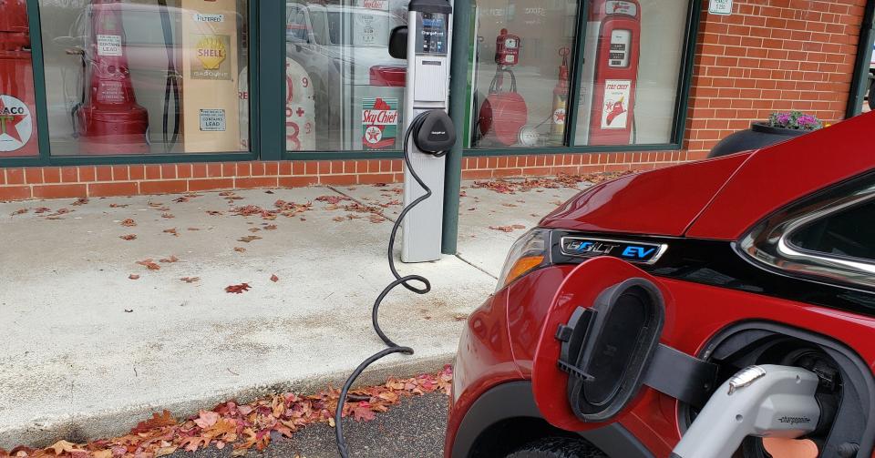 Myron Pitts&#39;s car gets a charge across from classic gas pumps on display at the Fayetteville Area Transportation and Local History Museum.