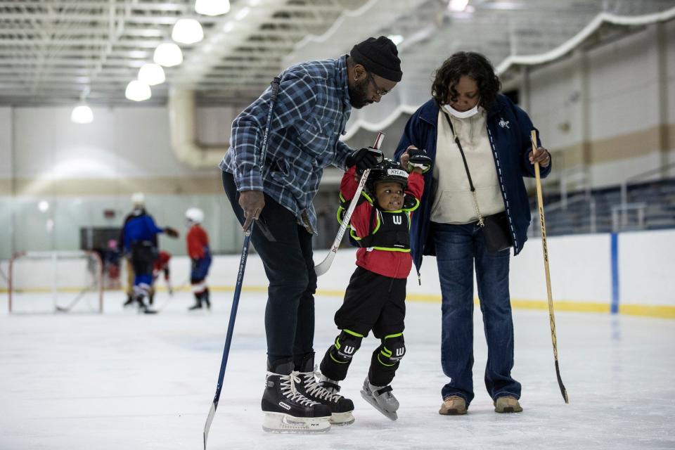 Rashard James and Cynthia Wardlaw help Kylan James, 2, skate across the ice, during hockey practice at Jack Adams Memorial Arena in Detroit on Wednesday, May 4, 2022.