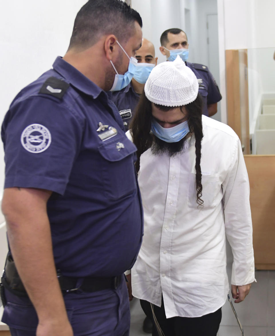 Israeli right-wing activist Amiram Ben-Uliel waits in a district court for a verdict in the city of Lod, Israel, Monday, May 18, 2020. An Israeli district court has convicted Ben-Uliel of murder in a 2015 arson attack that killed a Palestinian toddler and his parents. (Avshalom Sassoni/Pool Photo via AP)