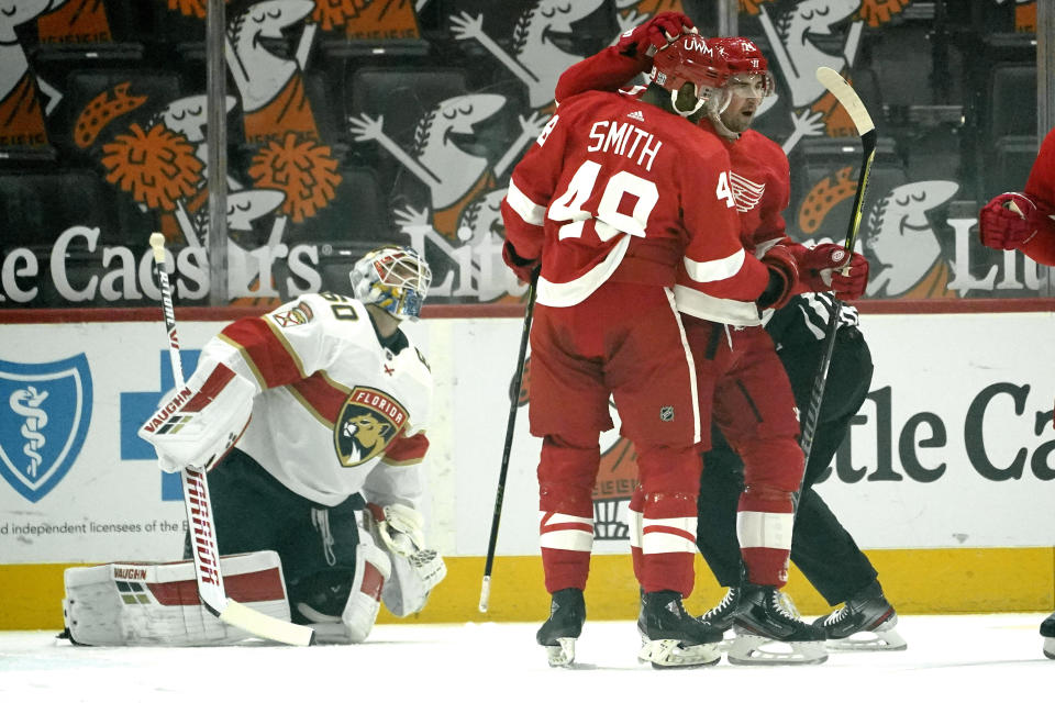 Detroit Red Wings center Dylan Larkin (71) celebrates his goal with Givani Smith as Florida Panthers goaltender Chris Driedger looks on in the first period of an NHL hockey game Sunday, Jan. 31, 2021, in Detroit. (AP Photo/Paul Sancya)