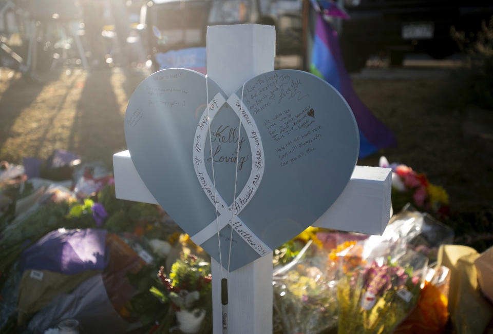 The sun shines on a cross for Kelly Loving, one of the victims of the mass shooing at Club Q, an LGBTQ bar on Monday, Nov. 21, 2022, in Colorado Springs, Colo. Crosses for each of the victims are being placed at the memorial outside the club by Redeemer Lutheran Church. (AP Photo/Parker Seibold)