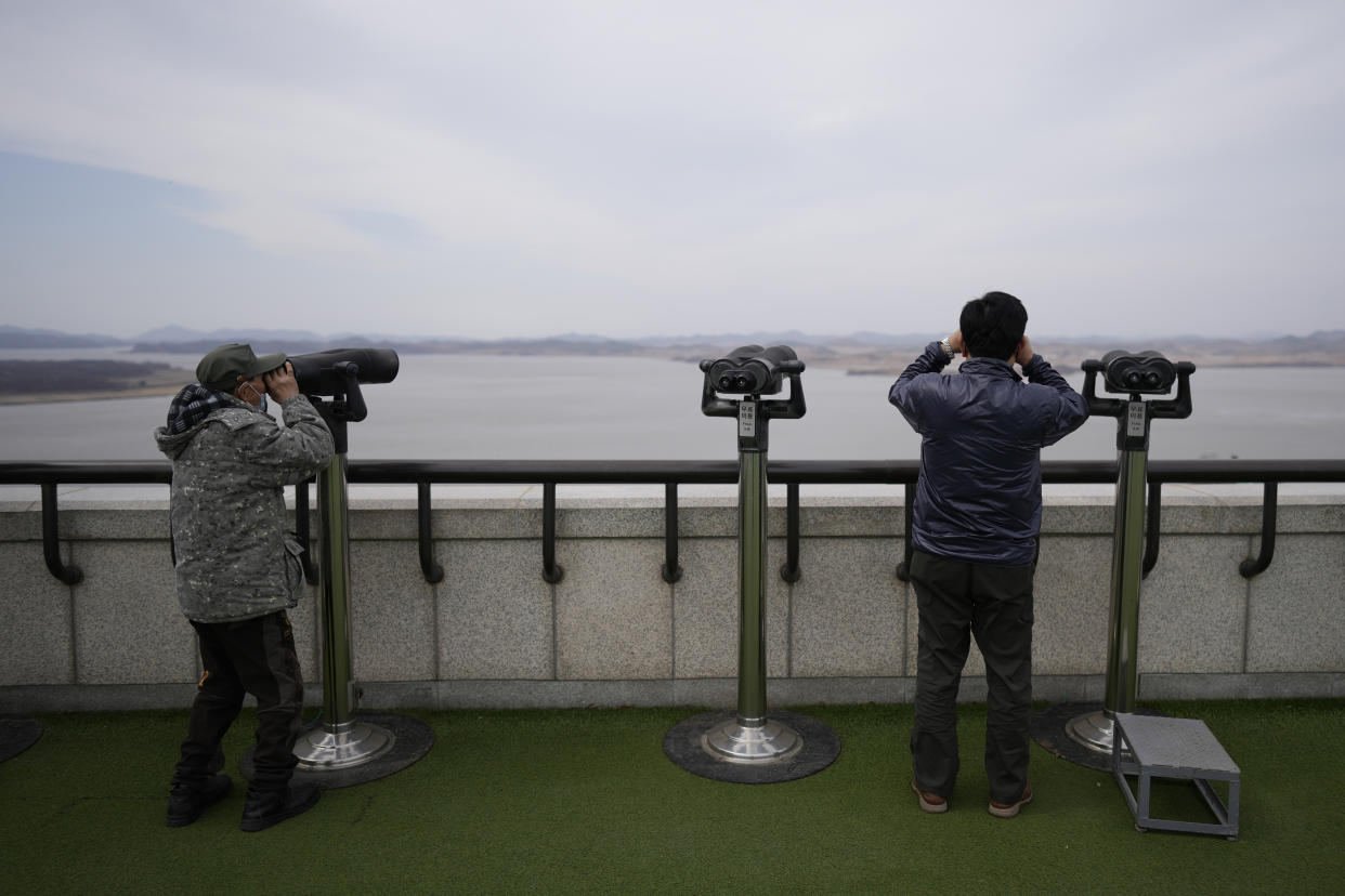 Visitors use binoculars to see the North Korean side from the unification observatory in Paju, South Korea, Tuesday, March 14, 2023. North Korea test-fired two short-range ballistic missiles in another show of force Tuesday, a day after the United States and South Korea began military drills that Pyongyang views as an invasion rehearsal. (AP Photo/Lee Jin-man)