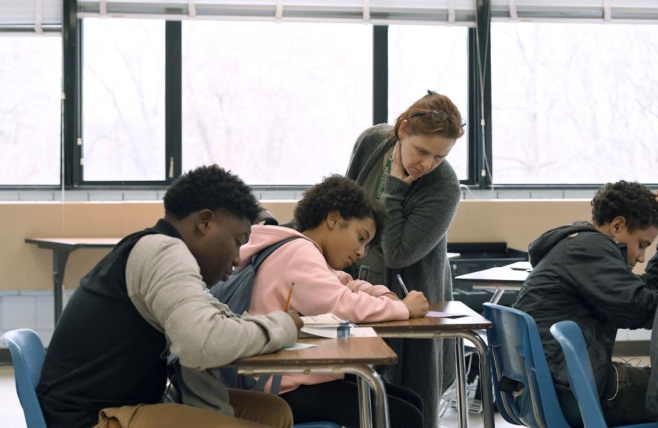 In this Nov. 7, 2019, photo, Crosby High School algebra teacher Jennifer Desiderio works with freshman students in her class in Waterbury, Conn. While students in the Waterbury public school district are predominantly black and Hispanic, the vast majority of its educators, as in school districts across the country, are white. (AP Photo/Jessica Hill)