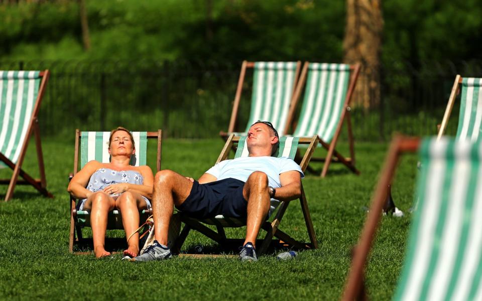 A couple enjoy the sun at Green Park in London  - Gareth Fuller/PA
