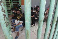 People wait to receive a shot of COVID-19 vaccine during a vaccination campaign at the Patriot Candrabhaga Stadium in Bekasi on the outskirts of Jakarta, Indonesia Friday, Nov. 26, 2021. Indonesia has significantly recovered from a mid-year spike in coronavirus cases and deaths that was one of the worst in the region, but with its vaccination drive stalling and holidays approaching, experts and officials warn the island nation could be set soon for another surge. (AP Photo/Achmad Ibrahim)