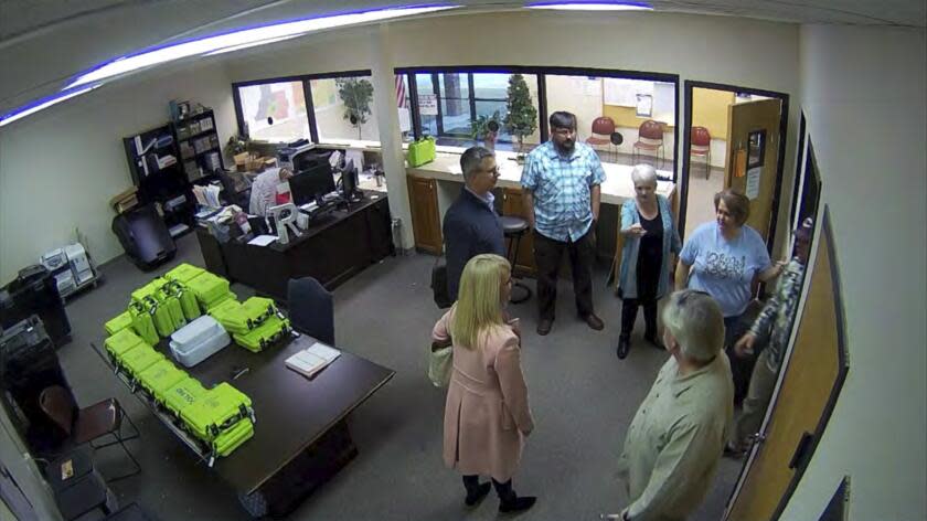 This Jan. 7, 2021, image taken from Coffee County, Ga., security video, appears to show Cathy Latham (center, long turquoise top), introducing members of a computer forensic team to local election officials. Latham was the county Republican Party chair at the time. The computer forensics team was at the county elections office in Douglas, Ga., to make copies of voting equipment in an effort that documents show was arranged by Sidney Powell and others allied with then-President Donald Trump. (Coffee County, Georgia via AP)