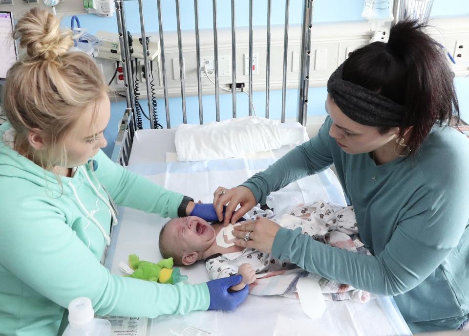 An Akron Children's Hospital nurse and Carlla Detwiler tend to David Detwiler. (Karen Schiely)