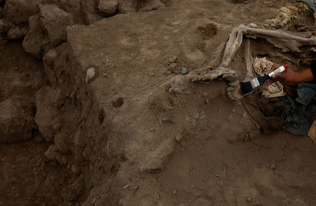 Archaeologist works at a tomb of one of sixteen Chinese migrants, discovered buried at the turn of the 20th century in the pre-colombian pyramid of Bellavista, according to Ministry of Culture, in Lima, Peru, August 24, 2017. REUTERS/Mariana Bazo