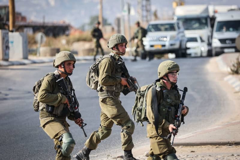 Israeli soldiers block a road in the West Bank. Ilia Yefimovich/dpa