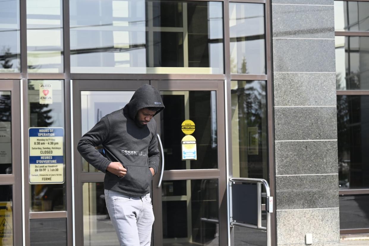 Ketiboua Kesse, 27, leaves Moncton provincial court on Wednesday. Kesse faces charges of possessing more than $5,000 obtained by crime and money laundering. (Pascal Raiche-Nogue/Radio-Canada - image credit)