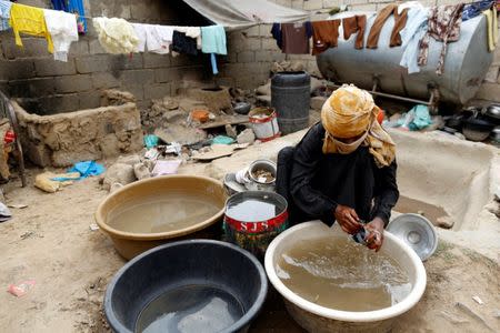 A woman displaced from the Red Sea port city of Hodeidah washes a cup outside a host family's house where she lives on the outskirts of Sanaa, Yemen July 10, 2018. REUTERS/Khaled Abdullah