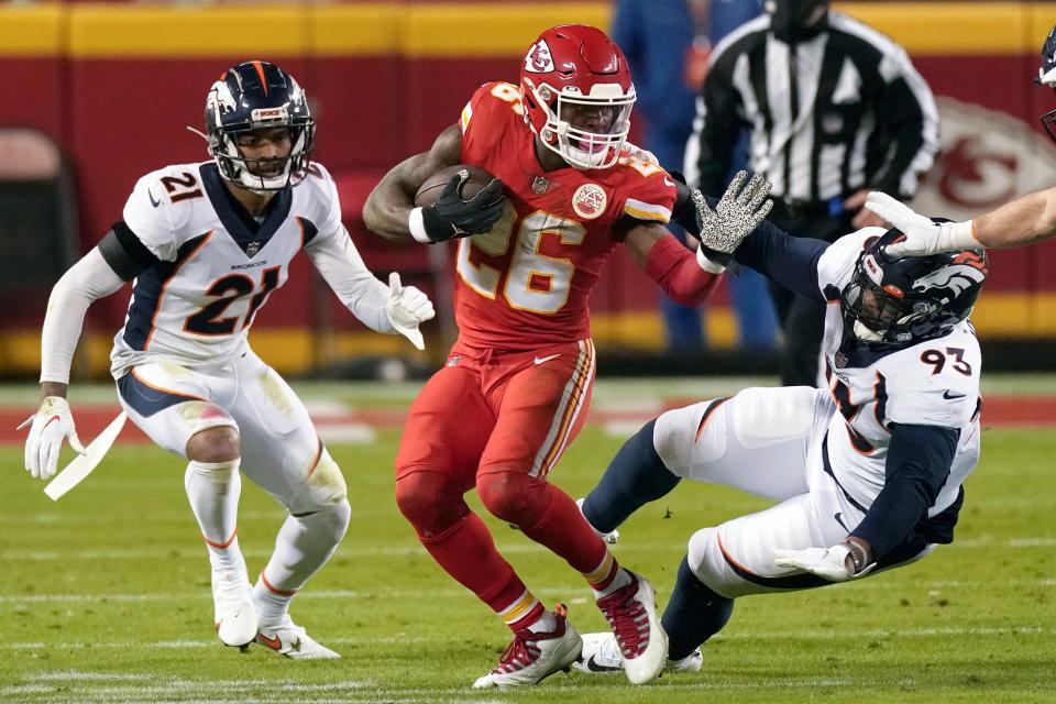 FILE - In this Sunday, Dec. 6, 2020 file photo, Kansas City Chiefs running back Le'Veon Bell (26) runs as Denver Broncos cornerback A.J. Bouye (21) and Denver Broncos defensive end Dre'Mont Jones (93) defend in the first half of an NFL football game in Kansas City, Mo. Le'Veon Bell and Tampa Bay Buccaneers Leonard Fournette go from losing squads to Super Bowl. (AP Photo/Charlie Riedel, File)