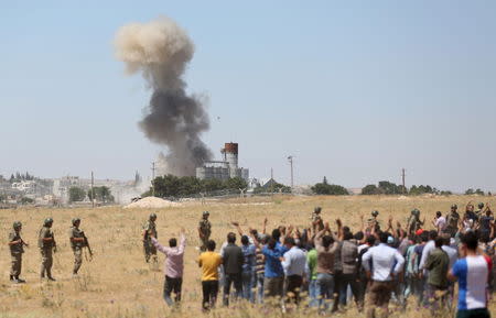 Smoke rises in the Syrian town of Kobani as it is seen from the Turkish border town of Suruc in Sanliurfa province, Turkey, June 25, 2015. REUTERS/Ali Sahin