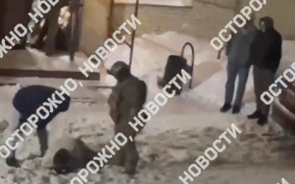 In this video posted by Russian media, a man wearing a mask and plain clothes kicks and punches a part-goer lying in the snow outside the club