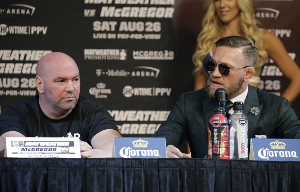 Dana White looks on while Conor McGregor speaks during a Mayweather-McGregor news conference on Wednesday. (Getty)