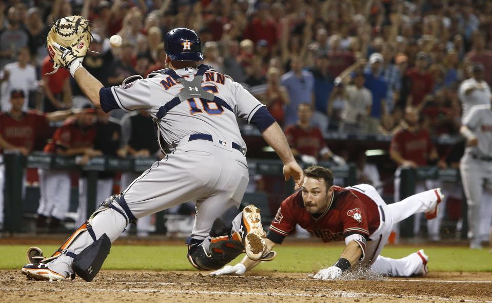 Arizona Diamondbacks’ A.J. Pollock (R) dives into home plate as Houston Astros catcher Brian McCann (L) reaches to catch the ball during the sixth inning of a baseball game Sunday, May 6, 2018, in Phoenix. (AP Photo/Ross D. Franklin)