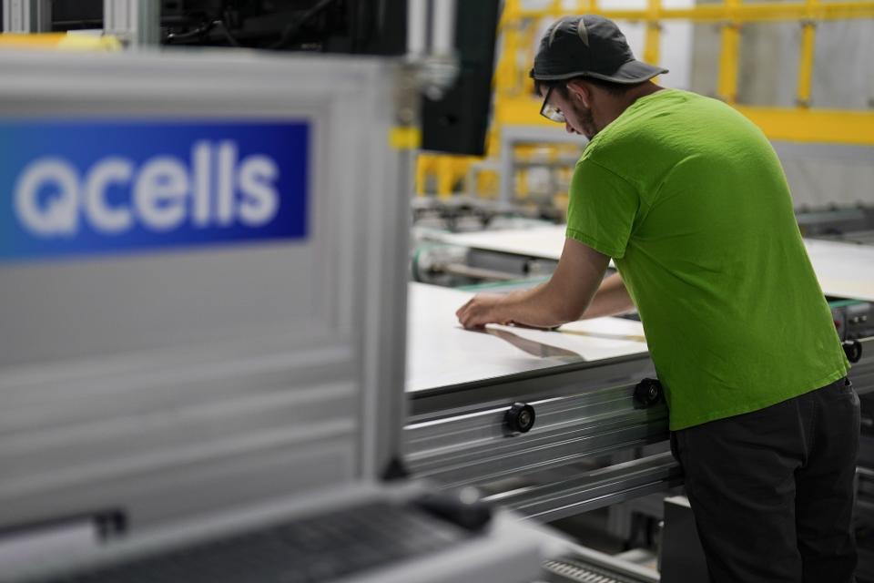 An employee works on a solar panel inside the Hanwha Qcells Solar plant, Monday, Oct. 16, 2023, in Dalton, Ga. The Korean company is opening what it says is the first solar panel factory to begin production in the U.S. since the passage of President Joe Biden’s signature climate legislation. (AP Photo/Mike Stewart)