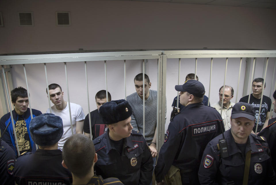 Defendants stand behind bars in a cage at a court room in Moscow, Russia, Monday, Feb. 24, 2014, where hearings started against opposition activists detained on May 6, 2012 during a rally at Bolotnaya Square. A Moscow judge on Friday, Feb. 21, 2014, convicted eight anti-government protesters of rioting during a 2012 protest against Vladimir Putin, following a trial seen as part of the Kremlin's efforts to stifle dissent. (AP Photo/Alexander Zemlianichenko)