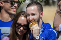 Artem Dolgopyat, Israeli artistic gymnastics men's gold medalist of Tokyo 2020, stands with his partner Maria Masha Sakovichas, while holding his medal on his arrival to Ben Gurion Airport, near Tel Aviv, Israel, Tuesday Aug. 3, 2021. The Ukrainian-born Israeli gymnast was hailed as a national hero for winning Israel's second-ever gold medal — and its first in artistic gymnastics. But the celebrations were tempered after his mother lamented that the country's authorities will not allow him to wed because he is not considered Jewish according to Orthodox law. (AP Photo/Ariel Schalit)