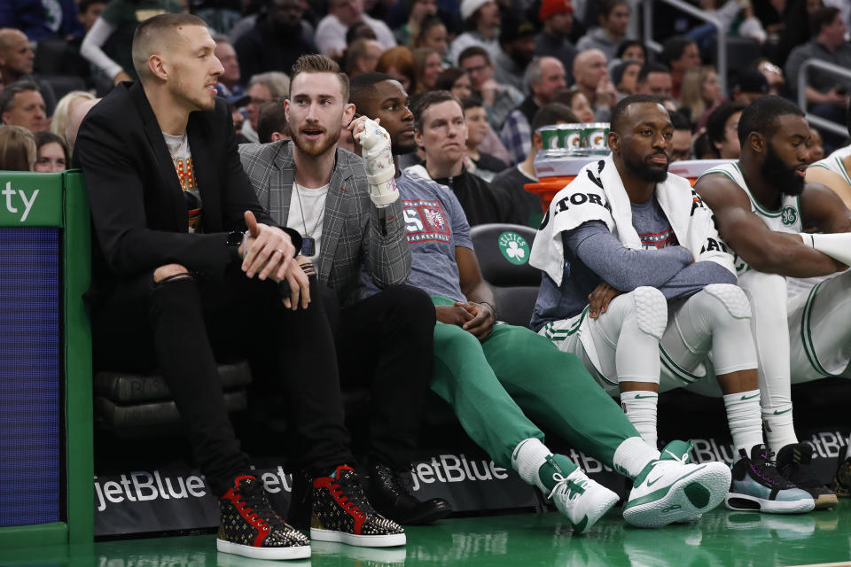 Injured Boston Celtics players Daniel Theis, left, and Gordon Hayward talk on the bench during the second quarter of the team's NBA basketball game against the Washington Wizards on Wednesday, Nov. 13, 2019, in Boston. (AP Photo/Winslow Townson)