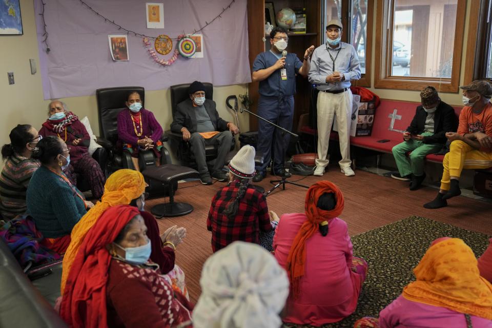 Dr. Subhankar Chakaborty, a gastroenterologist at Ohio State University Wexner Medical Center, top left, and Hari, a community health worker, answer a question during a session at Himalayan Day Care.