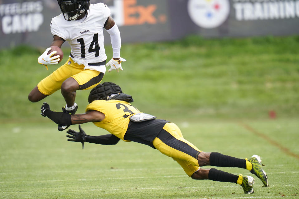 Pittsburgh Steelers wide receiver George Pickens (14) leaps over defensive back Justin Layne in a drill during practice at NFL football training camp in Latrobe, Pa., Thursday, Aug. 11, 2022. (AP Photo/Keith Srakocic)