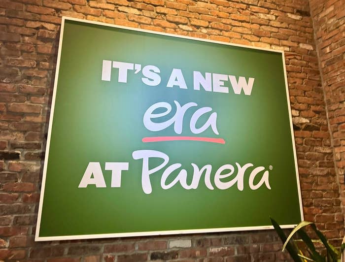 Sign on a brick wall stating "IT'S A NEW ERA AT Panera"