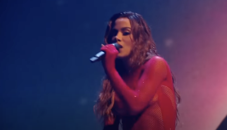 Anitta performing and holding a microphone