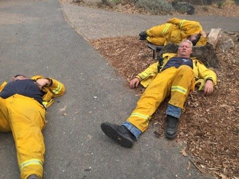 Exhausted firefighters try to get some rest on the ground using rocks as pillows (Sebastopol Fire Department/Facebook)