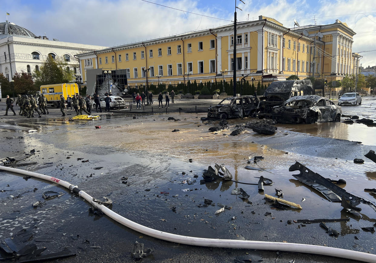 FILE - Rescue workers survey the scene of a Russian attack on Kyiv, Ukraine on Monday, Oct. 10, 2022. Russia has declared its intention to increase its targeting of Ukraine’s power, water and other vital infrastructure in its latest phase of the nearly 8-month-old war. (AP Photo/Adam Schreck, File)