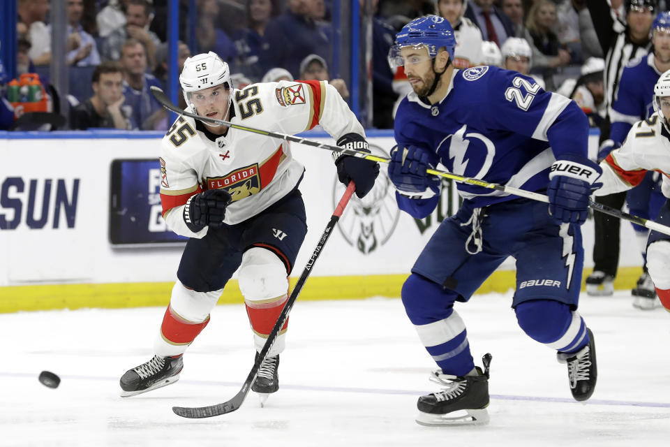 Florida Panthers center Noel Acciari (55) and Tampa Bay Lightning defenseman Kevin Shattenkirk (22) race for the puck during the third period of an NHL hockey game Monday, Dec. 23, 2019, in Tampa, Fla. (AP Photo/Chris O'Meara)