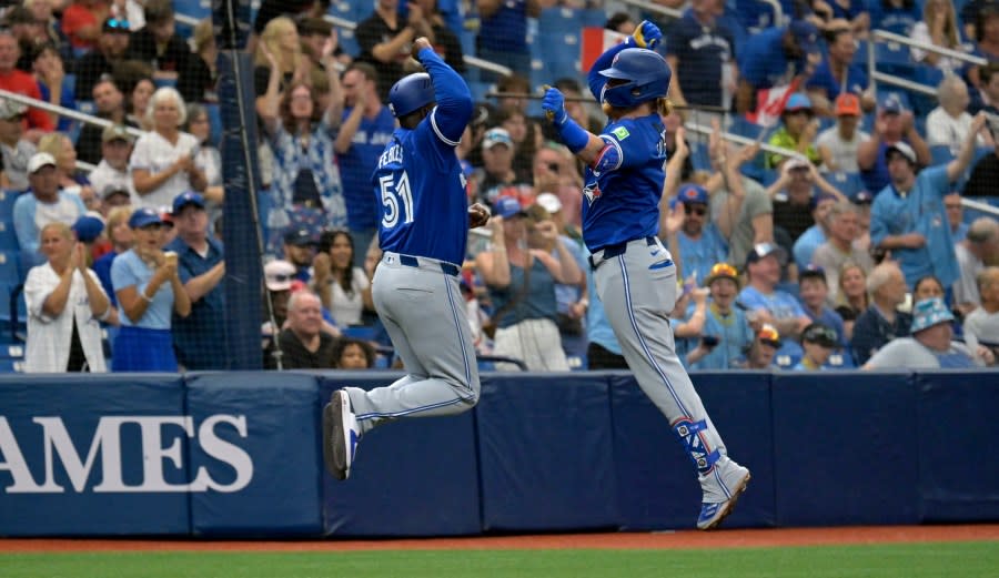 Toronto Blue Jays’ Justin Turner, right, celebrates with third base coach Carlos Febles after a solo home run off Tampa Bay Rays’ Tyler Alexander during the fifth inning of a baseball game Sunday, March 31, 2024, in St. Petersburg, Fla. (AP Photo/Steve Nesius)