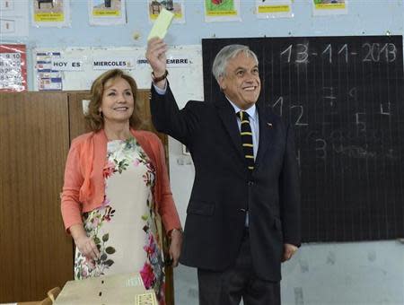 Chile's President Pinera accompanied by first lady Morel shows his vote during the presidential election at a school in Santiago