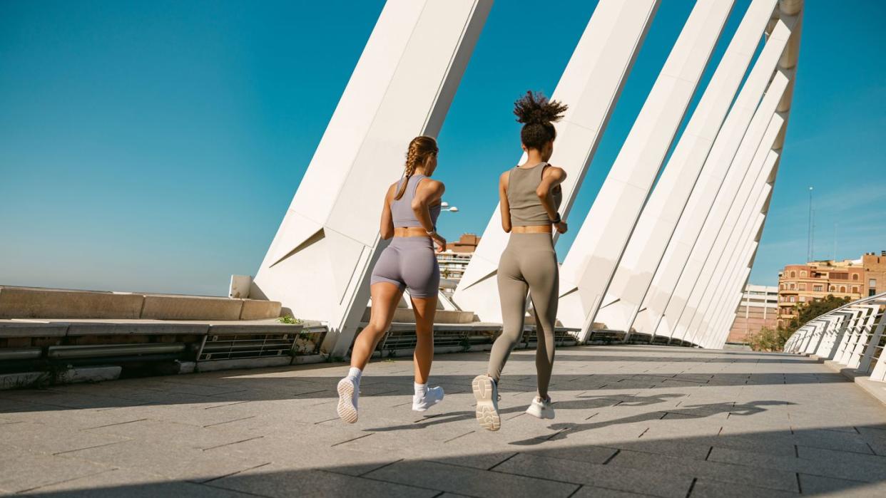 two women walking with surfboards