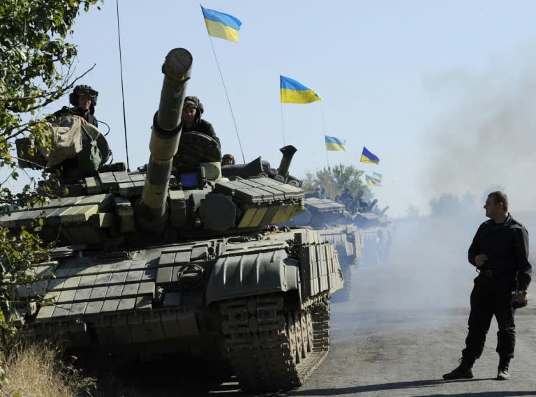 Ukrainian tanks ride from the front line near the village of Crymske in the Lugansk region on October 5, 2015