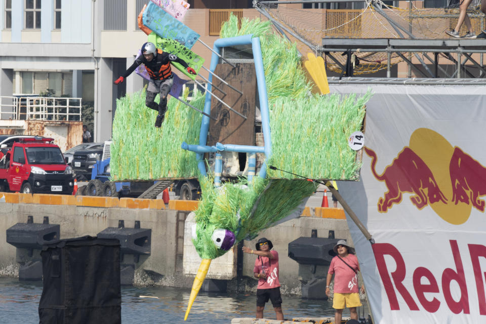 A team member jumps from a platform with a man made flying machine into the harbor in Taichung, a port city in central Taiwan on Sunday, Sept. 18, 2022. Pilots with homemade gliders launched themselves into a harbor from a 20-foot-high ramp to see who could go the farthest before falling into the waters. It was mostly if not all for fun as thousands of spectators laughed and cheered on 45 teams competing in the Red Bull “Flugtag” event held for the first time. (AP Photo/Szuying Lin)