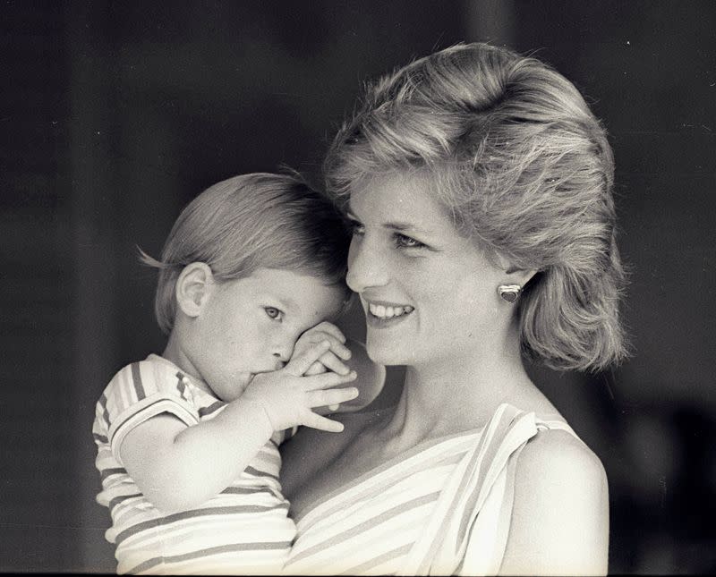FILE PHOTO: Young Prince Harry tries to hide behind his mother Diana, Princess of Wales