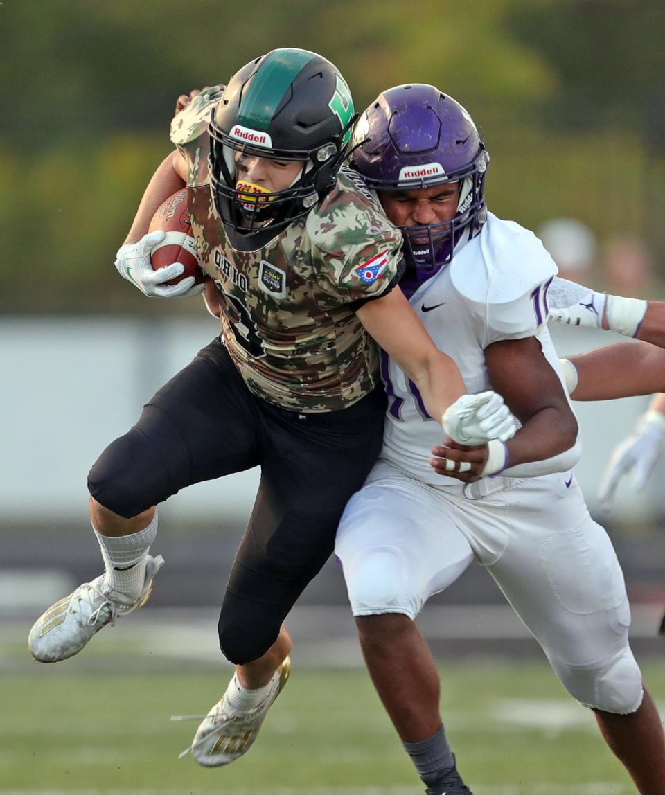 Highland wide receiver Jonathan Lima, left, is tackled by Barberton defensive lineman Roosevelt Andrews during the first half of a football game at Highland High School, Friday, Sept. 17, 2021, in Medina, Ohio.
