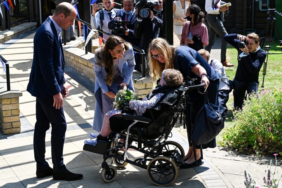 Prince William, Duke of Cambridge and Catherine, Duchess of Cambridge receive a bunch of flowers from a child during a visit to East Anglia’s Children’s Hospice in Milton