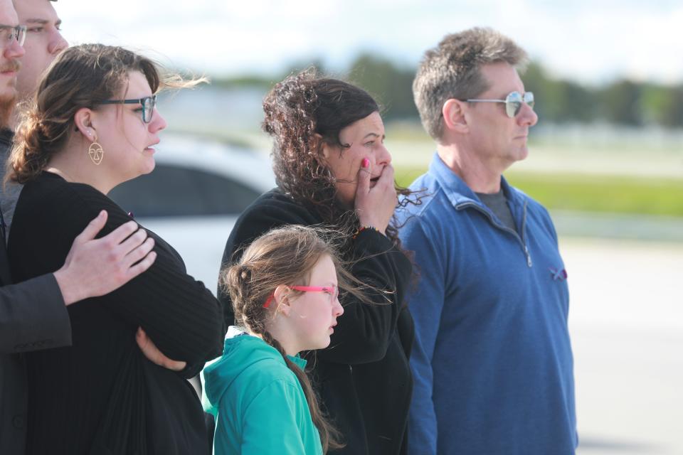 Carey Harris, second from right, cries as casket bearers prepare to place her daughter Kaylie's body in a hearse for the ride from John Glenn International Airport in Columbus, Ohio, to a funeral home in Springfield on May 11.