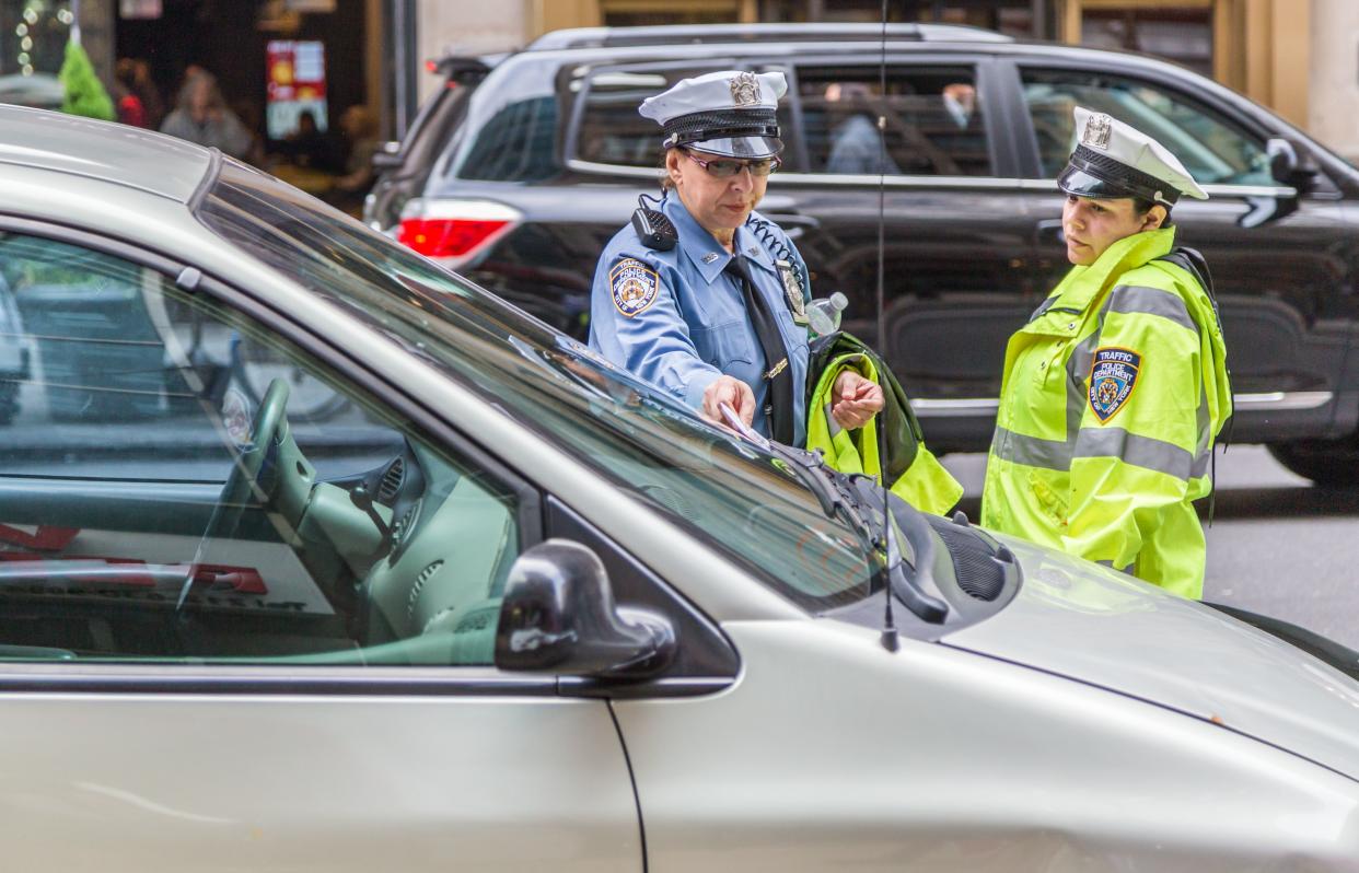 NYPD officer writing parking ticket in New York.