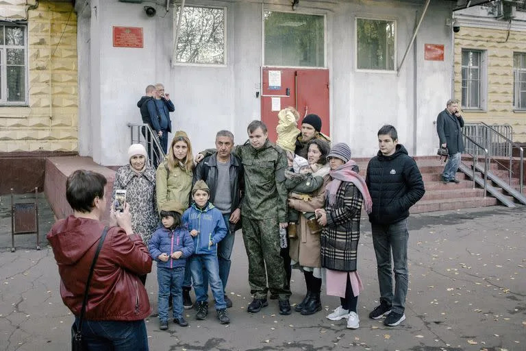 Hombres que han sido reclutados posan para una fotografía con familiares en una oficina de reclutamiento en Moscú el martes 11 de octubre de 2022