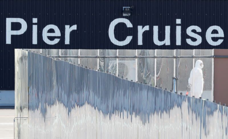 A worker in protective gear is seen while the cruise ship Diamond Princess is docked at Daikoku Pier Cruise Terminal in Yokohama, south of Tokyo