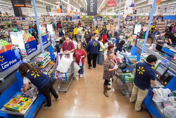 Several shoppers pay at a Walmart checkout counter