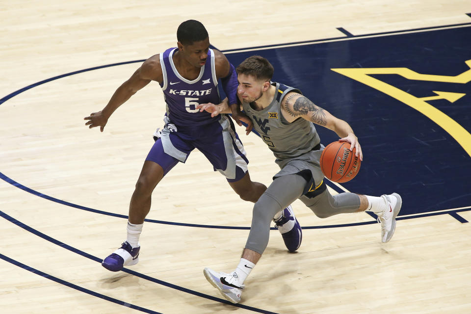 West Virginia guard Jordan McCabe (5) is defended by Kansas State guard Rudi Williams (5) during the first half of an NCAA college basketball game Saturday, Feb. 27, 2021, in Morgantown, W.Va. (AP Photo/Kathleen Batten)